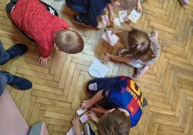 dzieci układają puzzle z misiem