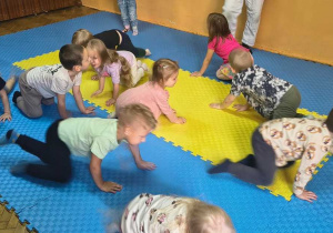 dzieci wykonują ćwiczenia czworakują