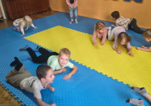 dzieci wykonują ćwiczenia czołgają się