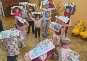 dzieci przykrywają głowę gazetą, żeby nie zmoknąć