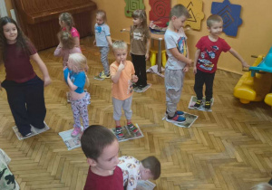 dzieci stoją na gazecie
