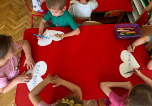 dzieci kolorują serduszka z magicznymi słowami