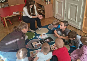 specjalistki i dzieci rozmawiając o sytuacjach na ilustracjach