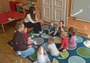 dzieci siedzą w kole