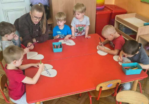 dzieci kolorują serduszka z magicznymi słowami