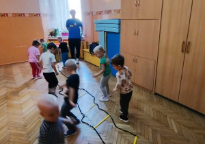 dzieci przeskakują drabinkę